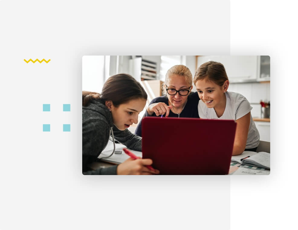 Mother and daughters looking at their laptop